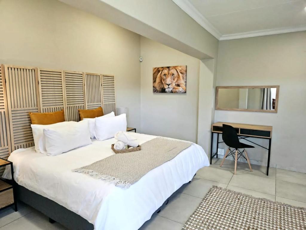 a bedroom with a large bed and a desk at Bosveld In Die Stad 2 in Alberton