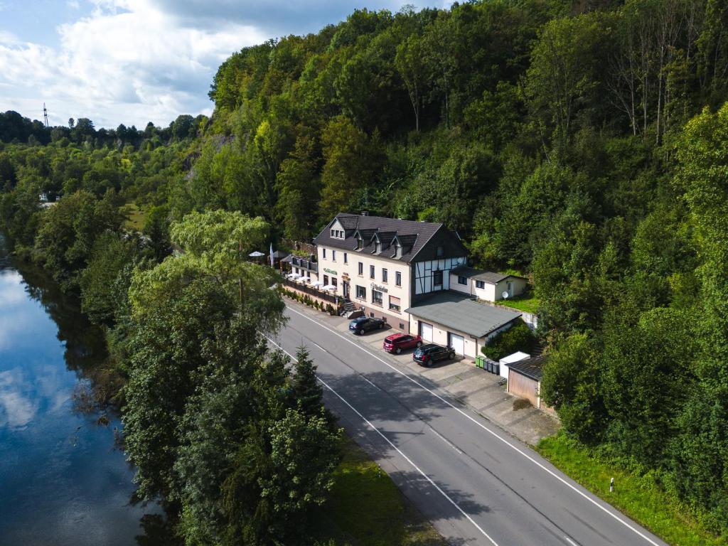 eine Luftansicht eines Hauses neben einem Fluss in der Unterkunft Hotel Haus Biggen in Attendorn