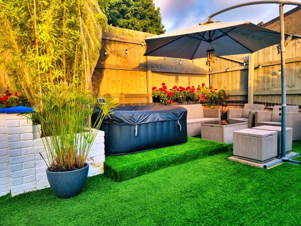 a backyard with an umbrella and green grass at Duchess of Cambridge in Copdock