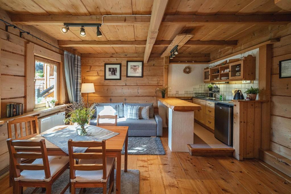 a kitchen and living room with a table and a couch at Apartamenty u Giewonta in Zakopane