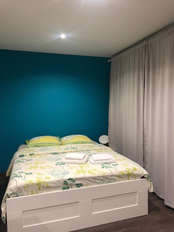 - une chambre dotée d'un lit avec un mur bleu dans l'établissement Grand studio, à Meythet