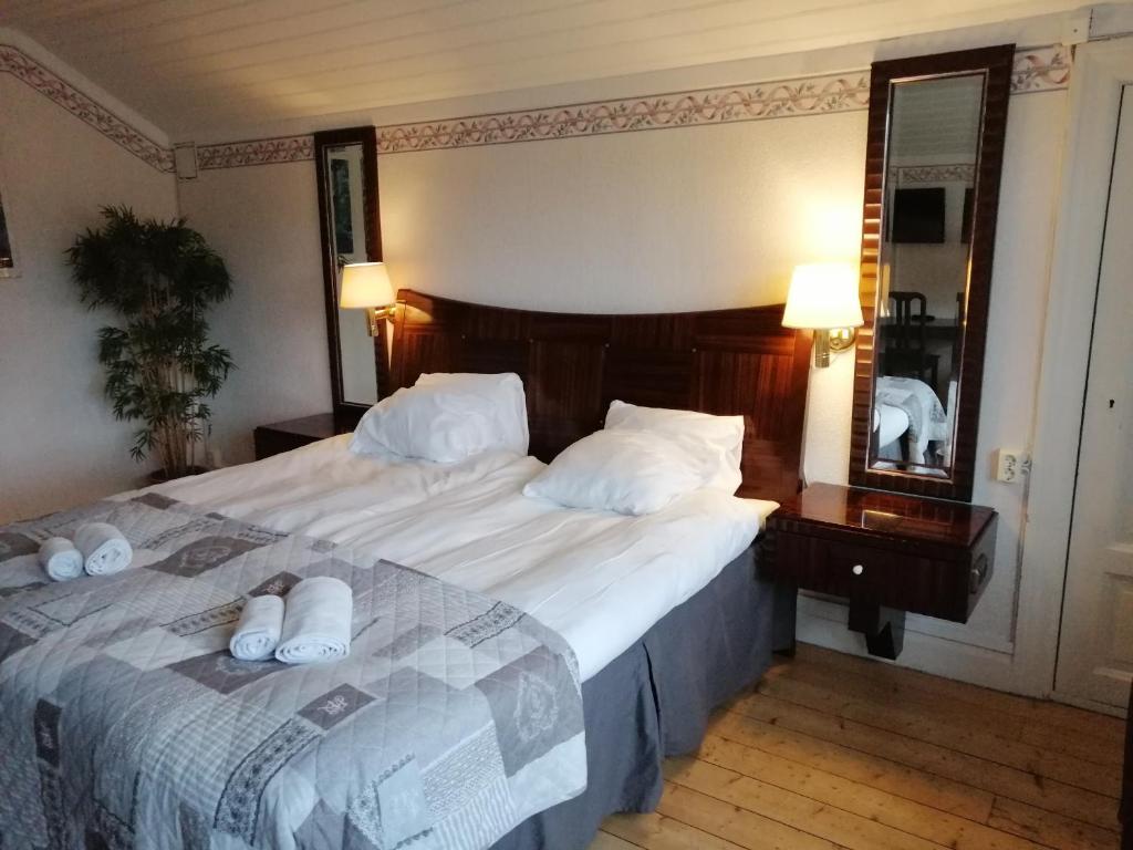 a bedroom with a large bed with white towels on it at Värdshuset Lugnet in Malung
