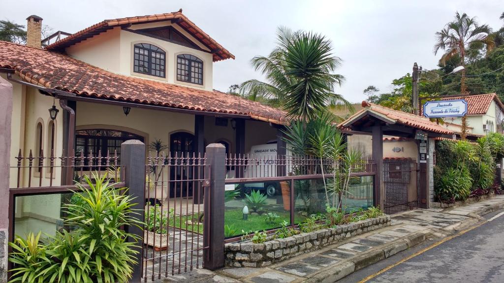 a house with a fence on a street at Pousada Nascente do Pirahy in Piraí