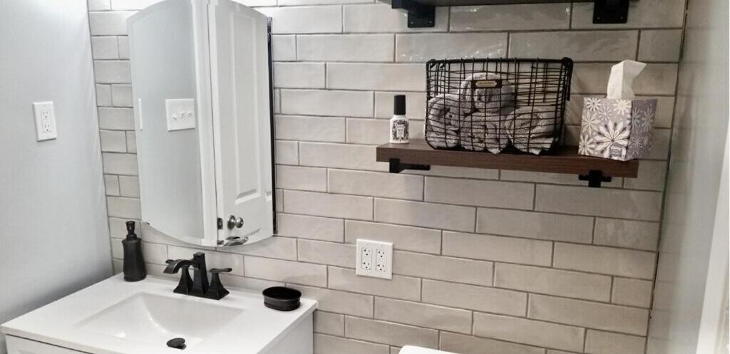 uma casa de banho com um lavatório e um espelho em 2 Bedroom Apt - Stylish, Modern, And Convenient! em Pittsburgh