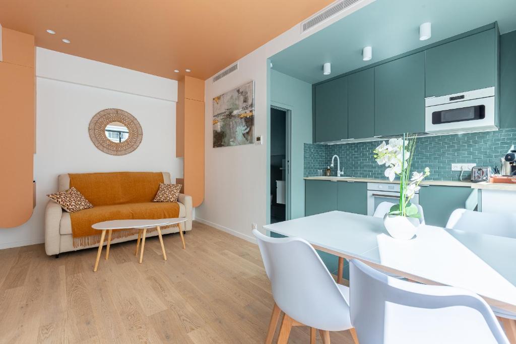 uma cozinha e sala de estar com mesa e cadeiras em Rome Batignolles - Luxe Charme - 2P em Paris