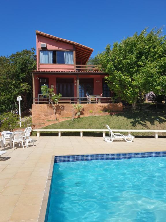 ein Haus mit einem Pool vor einem Haus in der Unterkunft Casa de 3 quartos em condomínio em Geriba in Búzios