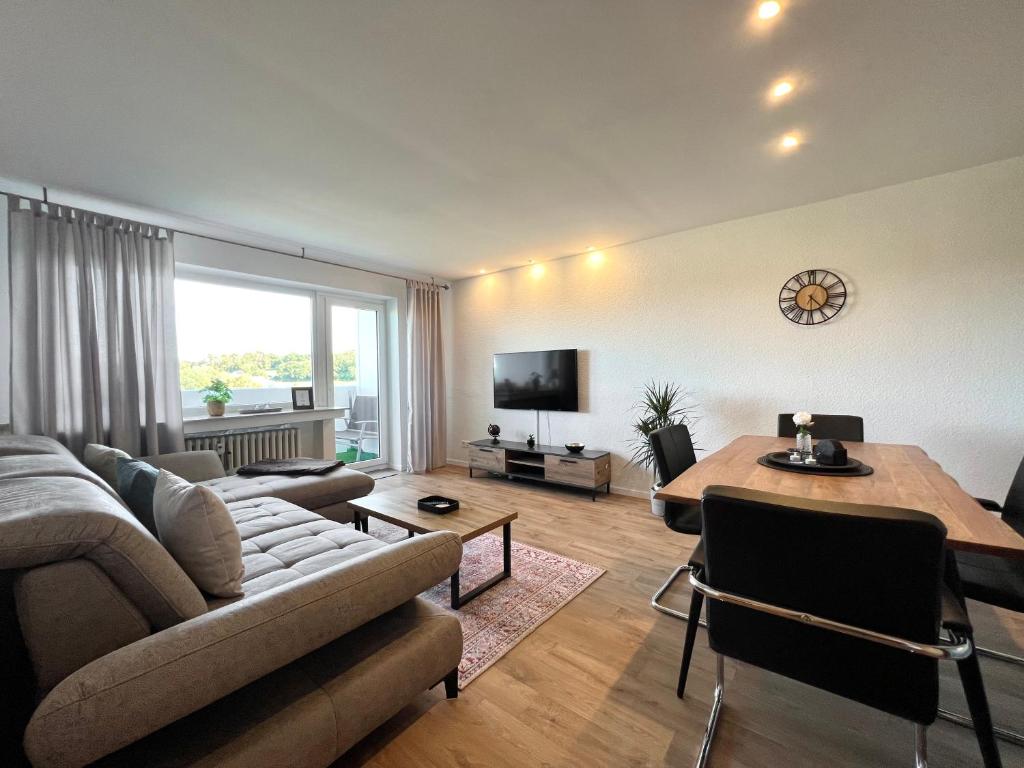 sala de estar con sofá y mesa en Stilvolles Apartment mit ländlichem Ausblick en Hattingen