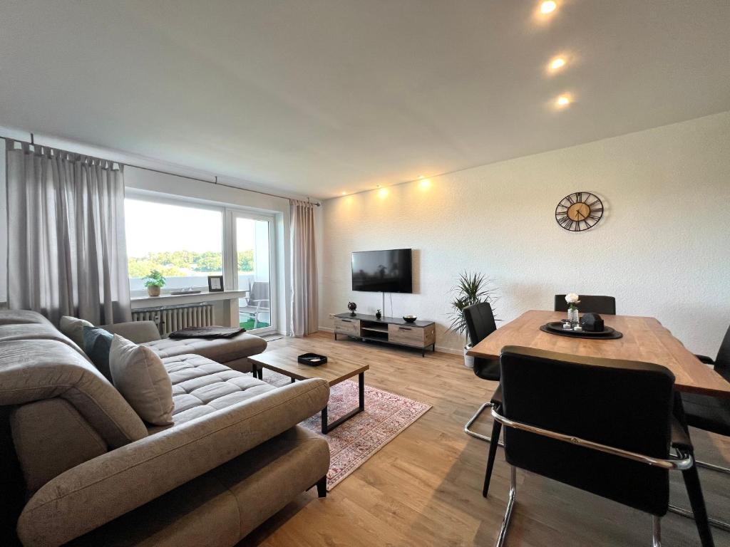 a living room with a couch and a table at Stilvolles Apartment mit ländlichem Ausblick in Hattingen