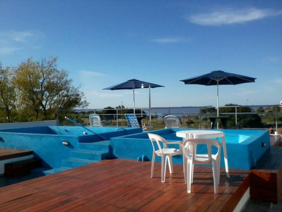 شقة حنا الفندقية في فيديراسيون: طاولة وكراسي على سطح مع مسبح