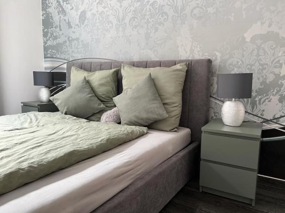 a bedroom with a bed with two end tables and two lamps at City Vibe Zentrum Zwickau in Zwickau