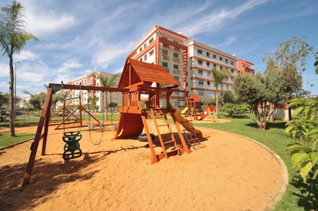 a playground with a swing set in a park at Mohammedia Nassim résidence Galia 