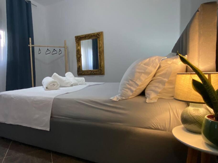 - une chambre avec un lit, 2 serviettes et un miroir dans l'établissement Cosy, private apartment in a family villa, à Tirana