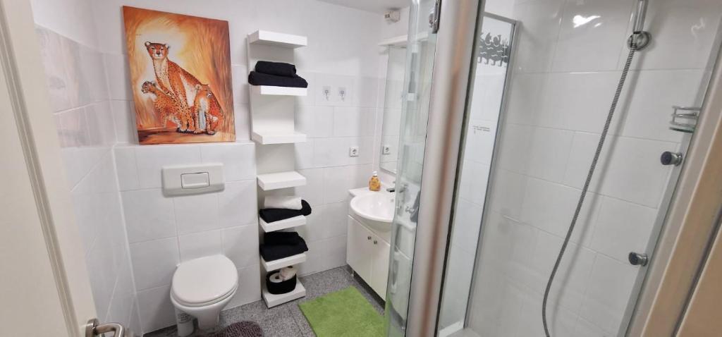 uma casa de banho com um chuveiro, um WC e um lavatório. em Am alten Siel em Wilhelmshaven