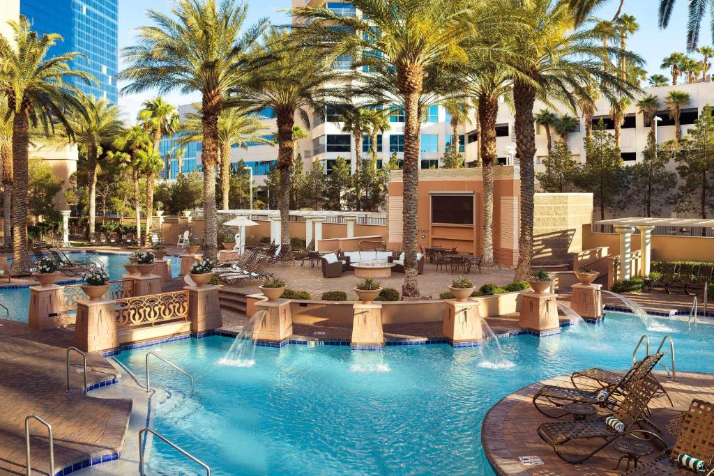 a large swimming pool with palm trees in a resort at Hilton Grand Vacations Club on the Las Vegas Strip in Las Vegas