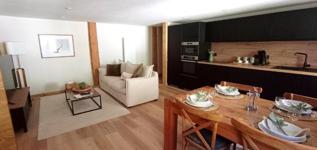 eine Küche und ein Wohnzimmer mit einem Tisch und Stühlen in der Unterkunft *Spacieux T3 Campagne proche lac* in Magland