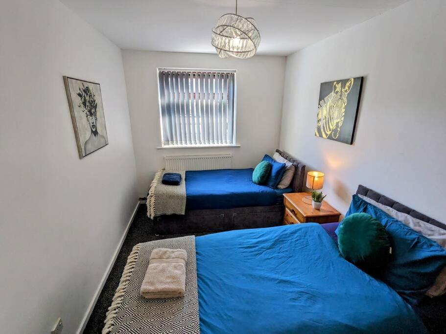 sypialnia z 2 łóżkami i niebieską pościelą w obiekcie Hs UK Homes Beautiful 2 bed in Bradford w mieście Bradford