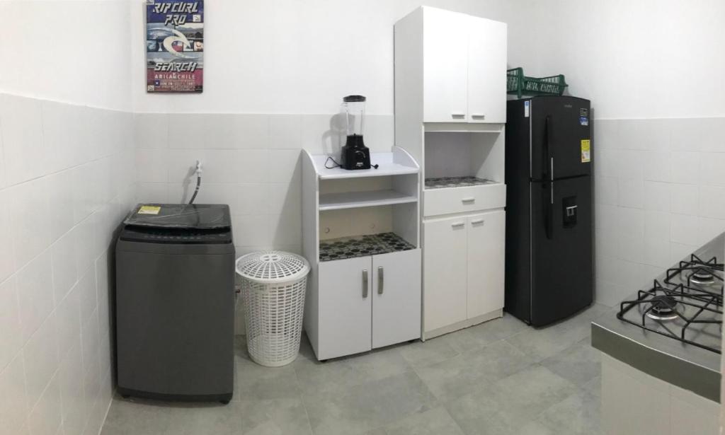 a kitchen with a refrigerator and a trash can at Rest 1 in Santa Marta
