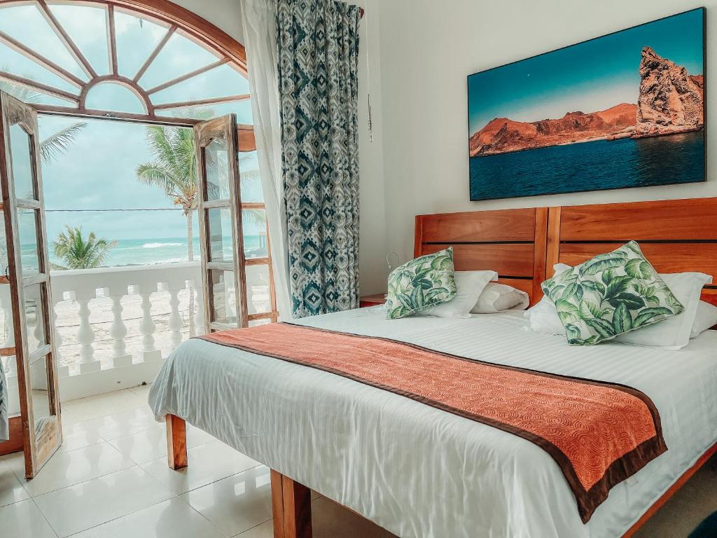 a bedroom with a bed with a view of the ocean at Hotel Albemarle in Puerto Villamil