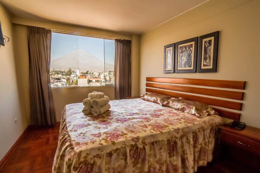 ein Schlafzimmer mit einem Teddybär, der auf einem Bett sitzt in der Unterkunft Hotel JKalixto in Cayma