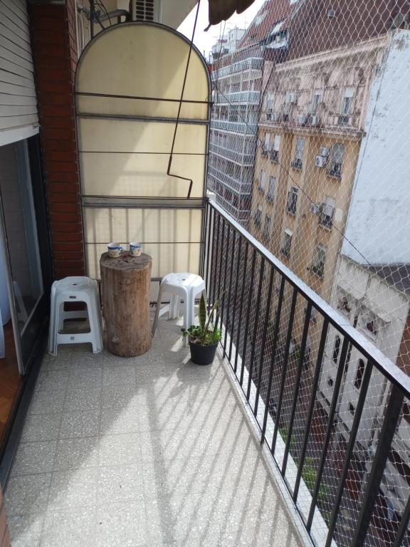 un balcón con 2 taburetes y un barril en JUNIN APPARTEMENT TWO en Buenos Aires
