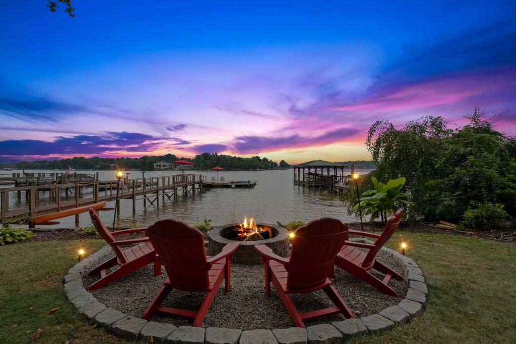 una hoguera con 2 sillas y una mesa junto a un muelle en Commodore Bay Waterfront Home on Lake Norman!, en Mooresville