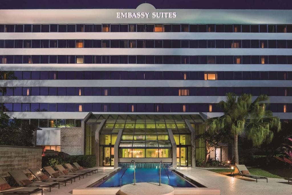 a hotel with a swimming pool in front of a building at Embassy Suites by Hilton Orlando International Drive ICON Park in Orlando