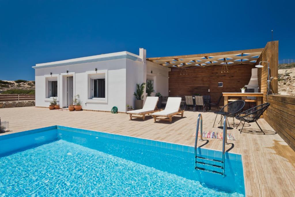 een villa met een zwembad en een patio bij Vènto villa in Karpathos