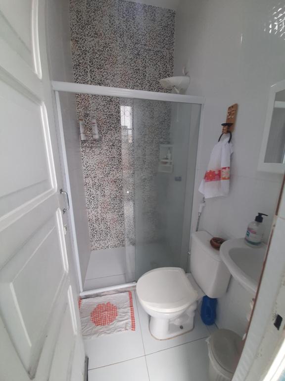 uma pequena casa de banho com chuveiro e WC em Quartos Aconchegantes prox Pelourinho, Metrô e Arena F Nova em Salvador