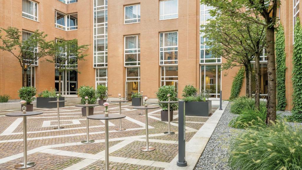 a courtyard with potted plants in front of a building at Hilton Munich City in Munich