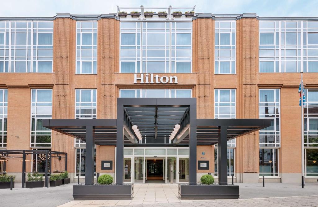 an exterior view of a brick building with a hilton sign at Hilton Munich City in Munich
