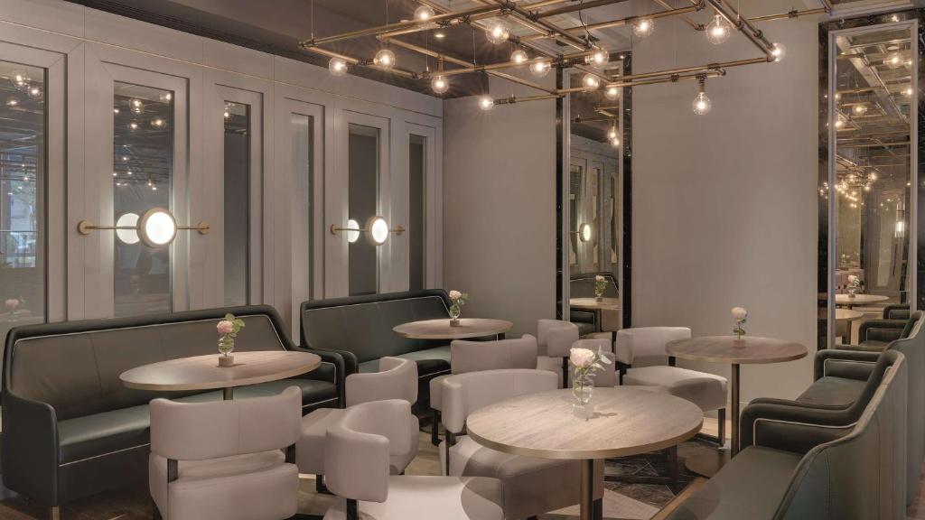 a restaurant with tables and chairs and lights at Hilton Munich City in Munich