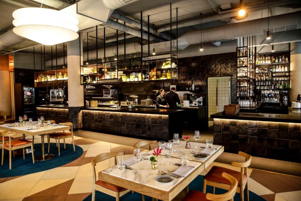 a restaurant with tables and chairs and a bar at Hilton Munich City in Munich