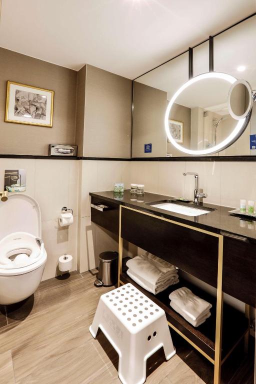 a bathroom with a toilet and a sink and a mirror at Hilton Munich City in Munich