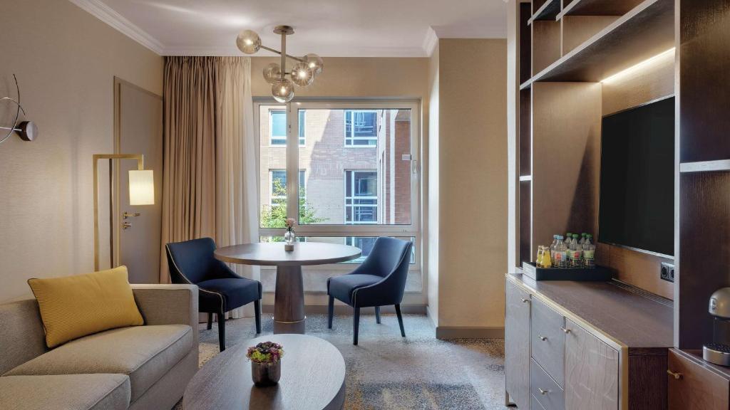 a living room with a couch and a table at Hilton Munich City in Munich