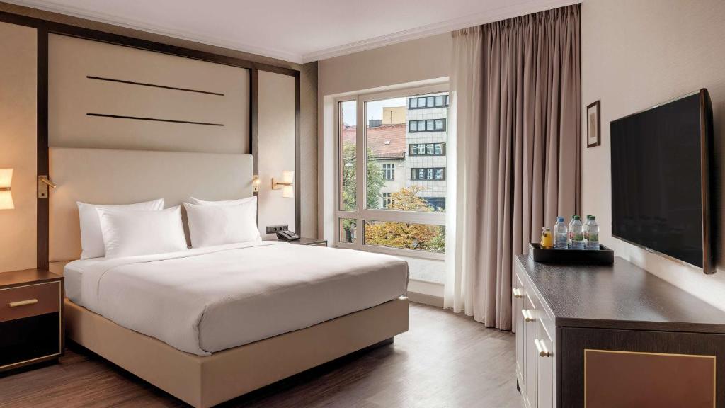 a hotel room with a bed and a television at Hilton Munich City in Munich