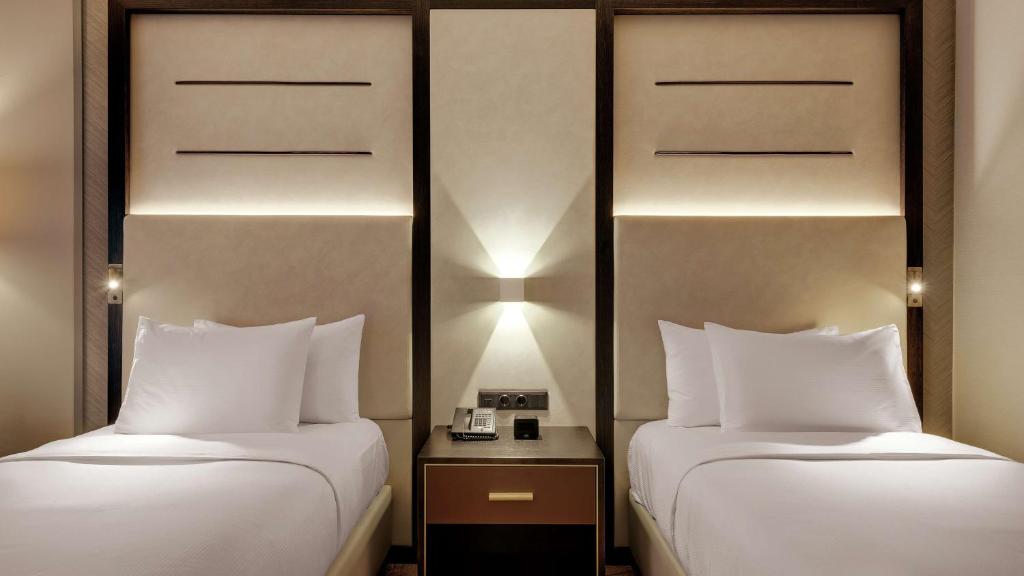 two beds sitting next to each other in a room at Hilton Munich City in Munich
