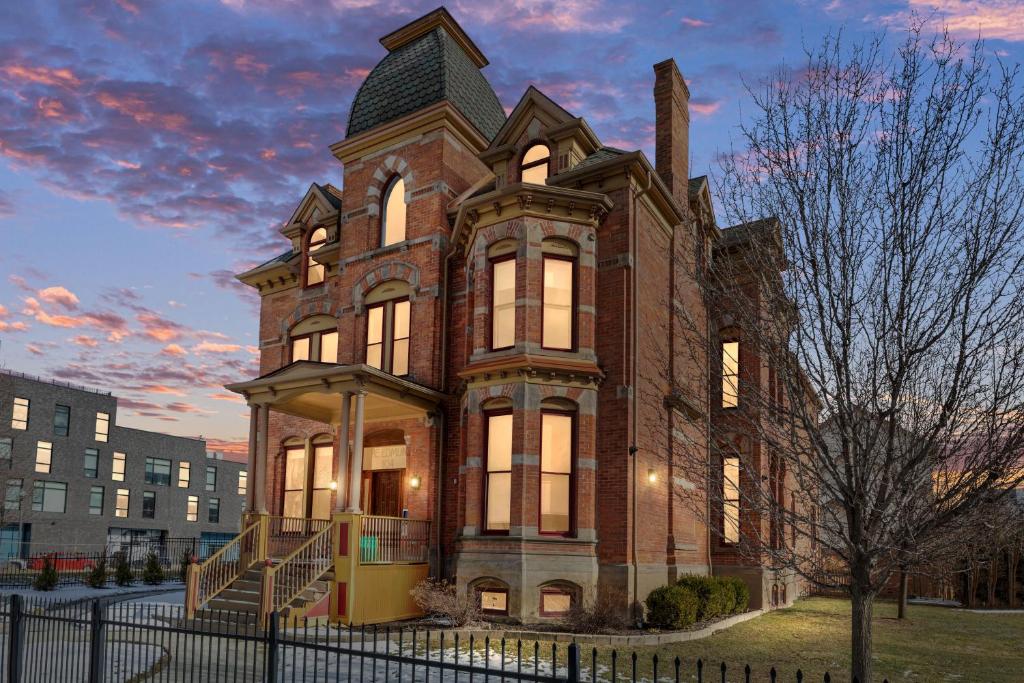 un gran edificio de ladrillo con una torre en The Lumber Baron's Mansion: 2 King Suites, 2.5BA + Gym, en Detroit