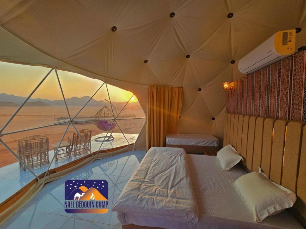a bedroom with a tent with a view of the desert at Nael Bedouin camp in Wadi Rum