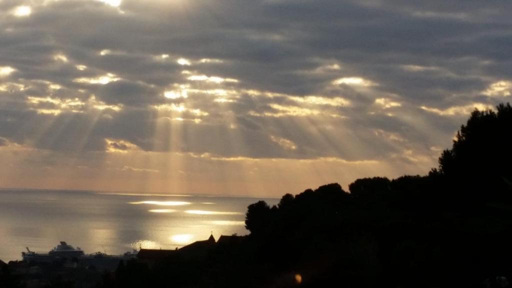 a view of the ocean with the sun breaking through the clouds at Chez Mélanie in Marseille