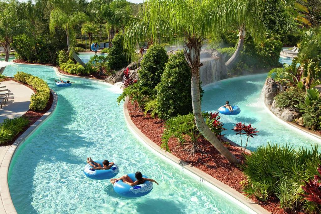 a group of people tubing down a lazy river at a resort at Hilton Orlando in Orlando