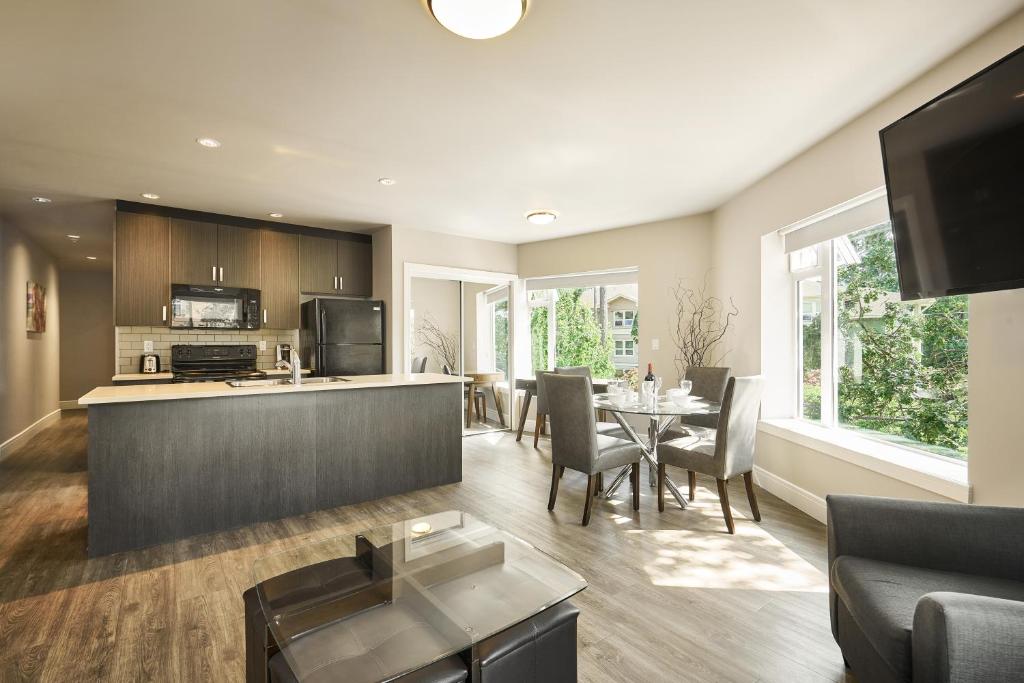 a kitchen and living room with a table and chairs at SoLo Suites in Victoria
