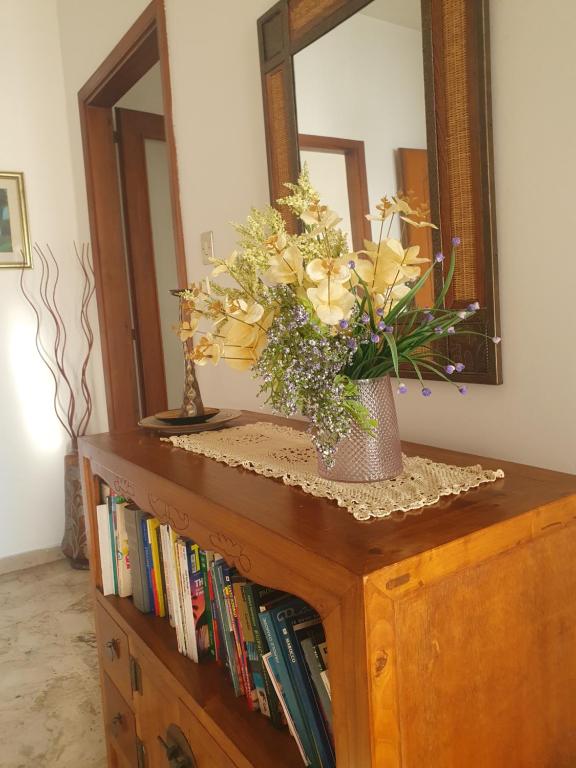un vase avec des fleurs au-dessus d'une commode avec un miroir dans l'établissement Margherita 64, à Pescara