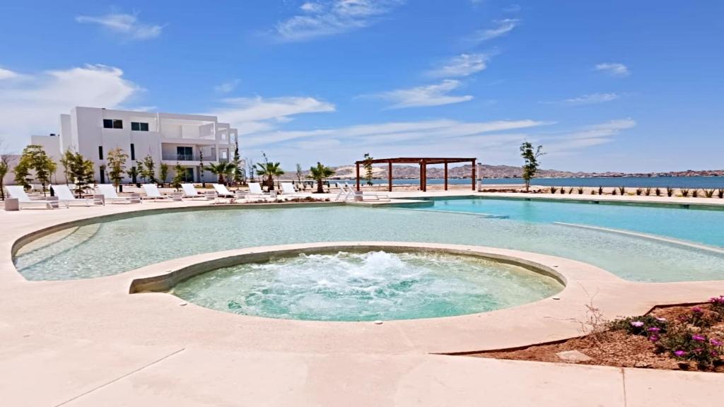 une grande piscine avec des chaises et un kiosque dans l'établissement Brand New Condo Costa Divina B2 By Kivoya, à Puerto Peñasco