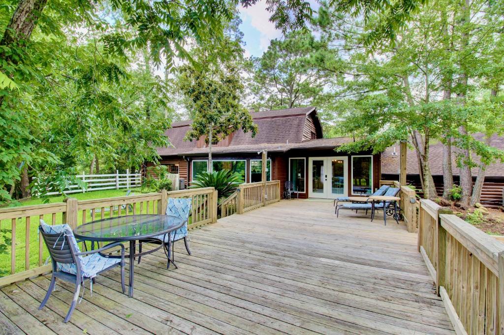a wooden deck with a table and chairs on it at Unplug and Recharge: Bayou Log Cabin Retreat in Dickinson