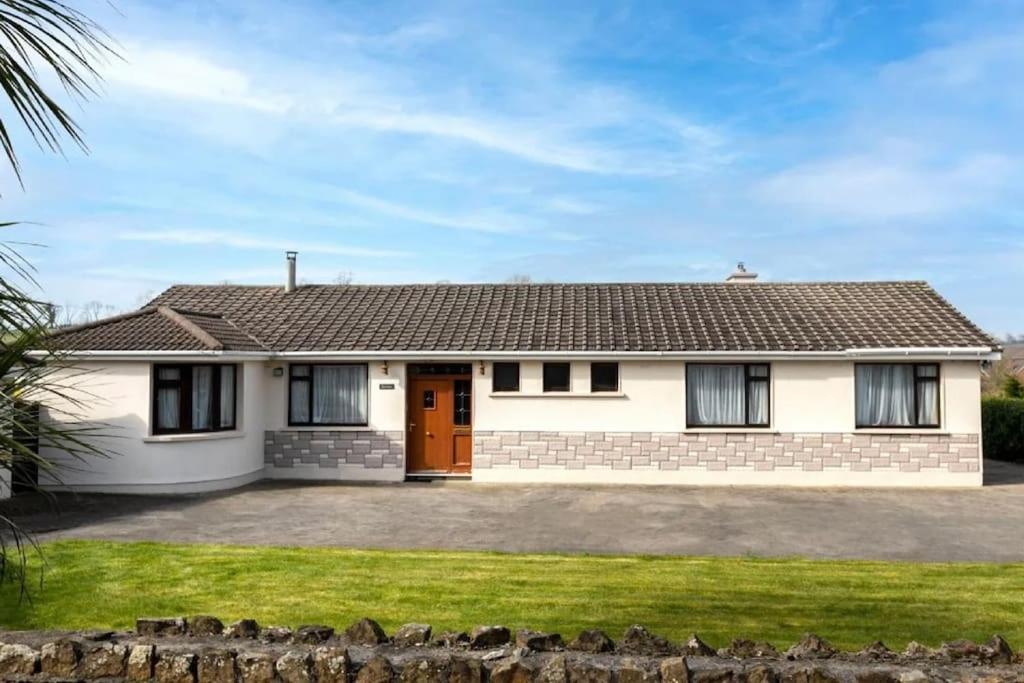 une maison blanche avec une porte rouge dans l'établissement Quiet self-catering holiday home with surrounding lakes, à Bailieborough