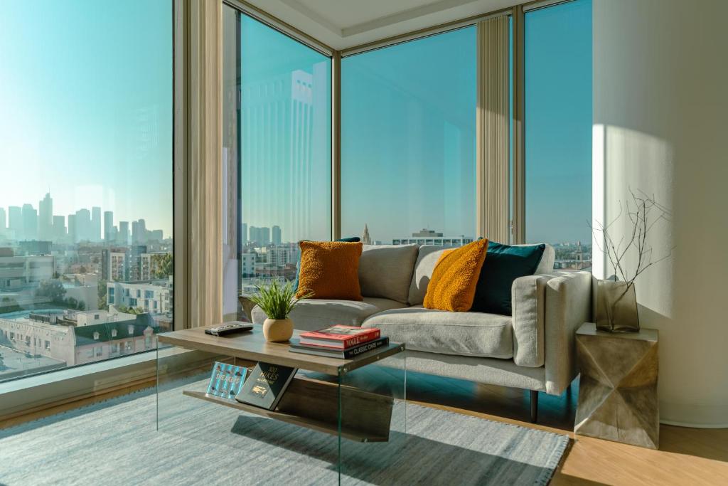 een woonkamer met een bank en grote ramen bij Modern Luxury 2 Bd Apt with Pool Views and free parking in Los Angeles