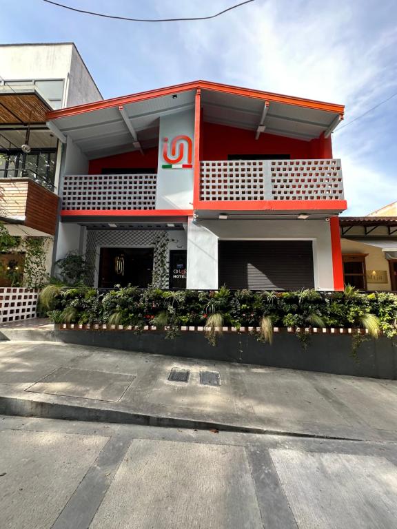 a red and white building with a balcony at CoLinkHouse Hotel in Medellín