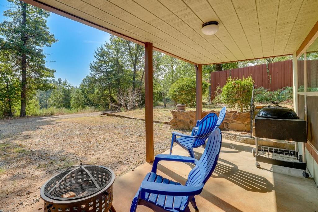 two blue chairs sitting on a porch with a grill at Cozy East Texas Retreat Near Lake O the Pines! in Avinger