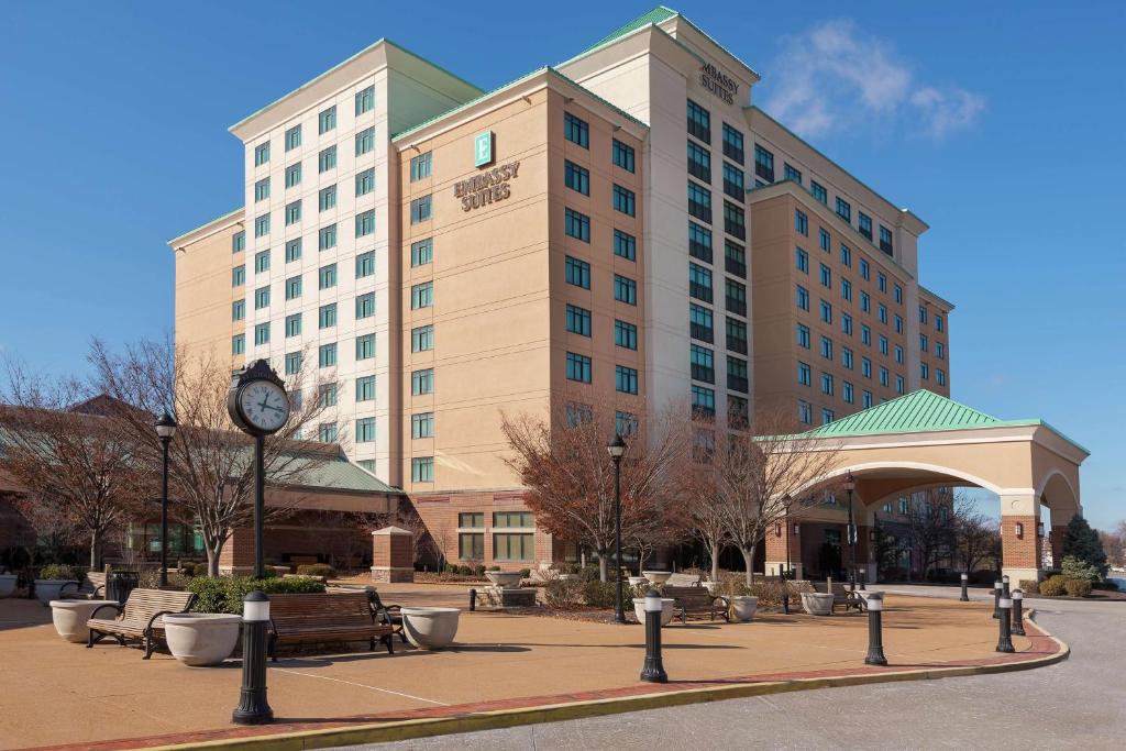 a large building with a clock in front of it at Embassy Suites by Hilton Saint Louis Saint Charles in St. Charles
