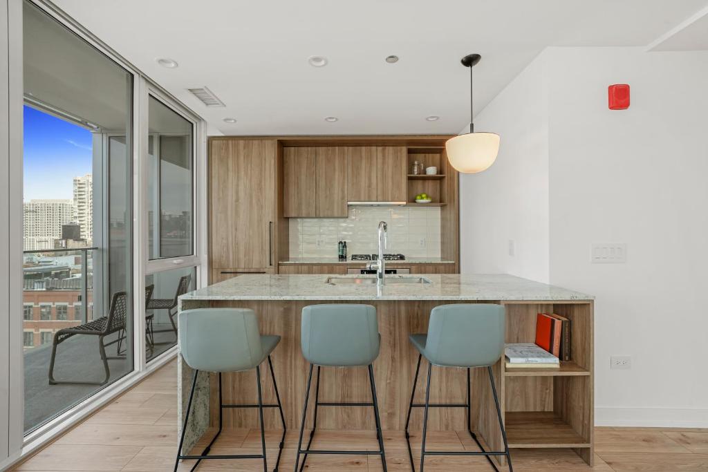 a kitchen with a large island with blue chairs at Level Chicago River North in Chicago